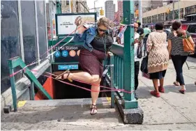  ?? THE ASSOCIATED PRESS ?? A commuter exits a closed-off station after a subway train derailment Tuesday in the Harlem section of New York.