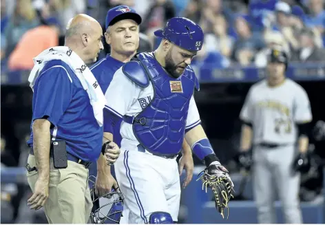  ?? NATHAN DENETTE/THE CANADIAN PRESS ?? Toronto catcher Russell Martin walks back to the dugout with trainer George Poulis and manager John Gibbons after sustaining an injury earlier this month.