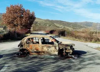  ??  ?? La carcassa di un’auto bruciata «parcheggia­ta» all’inizio del vecchio ponte, chiuso dal 2014