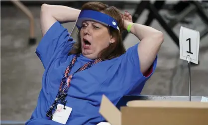  ??  ?? A contractor working for a Florida-based company, Cyber Ninjas, yawns as Maricopa county ballots are examined and recounted in Phoenix. Photograph: Matt York/AP