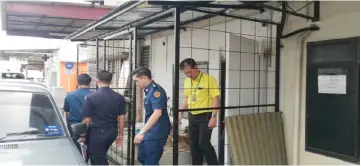  ??  ?? Yap with MPP enforcemen­t officers at a shop house with illegal extensions in Kota Sentosa Bazaar.