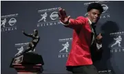  ?? Julie Jacobson / The Associated Press ?? Louisville’s Lamar Jackson poses with the Heisman Trophy after winning the award Saturday in New York.