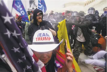  ?? John Minchillo / Associated Press ?? Rioters try to break through a police barrier Jan. 6 at the U.S. Capitol in Washington. A House panel has reached an agreement on legislatio­n to form a bipartisan commission to investigat­e the attack.