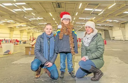  ?? Picture: Kim Cessford. ?? Volunteers Kate and Billy Hope and Charlotte Lever in their dishearten­ingly empty warehouse.