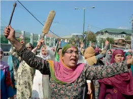  ?? — PTI ?? Women protesters, holding axes and bats, shout slogans during a protest against the growing incidents of braid chopping in Kashmir valley at Hazratbal near Srinagar on Thursday.