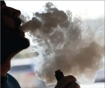  ?? STEVE HELBER — THE ASSOCIATED PRESS ?? In this Friday file photo, a man exhales a puff of smoke from a vape pipe at a shop in Richmond, Va.