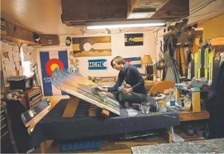  ?? Photos by RJ Sangosti, The Denver Post ?? Peri Duncan, manager of Colorado Ski Chairs, works on painting furniture made out of old skis in Manitou Springs.