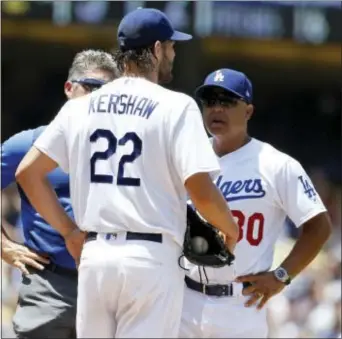  ?? ALEX GALLARDO — THE ASSOCIATED PRESS ?? Dodgers starting pitcher Clayton Kershaw, center, talks with manager Dave Roberts, right, and trainer Nathan Lucero during the second inning of a game against the Braves in Los Angeles, Sunday.