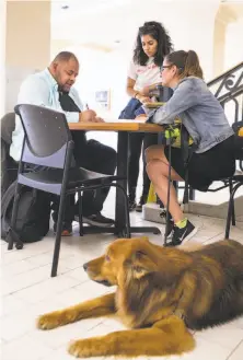  ?? Jana Asenbrenne­rova / Special to The Chronicle ?? Tenderloin resident Tony Page completes his ballot at San Francisco City Hall, aided by Denisse Manrique (center) and Christy Shirilla. Groups are helping homeless people vote.