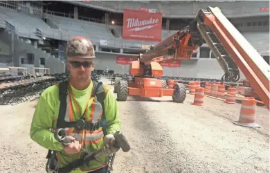  ?? JAMES B. NELSON / MILWAUKEE JOURNAL SENTINEL ?? Ironworker Brandon Ladwig bolted a ceremonial beam into place high above the Milwaukee Bucks arena during Thursday's topping off ceremony. About 1,000 people gathered to celebrate. See a gallery of photos at jsonline.com/news.