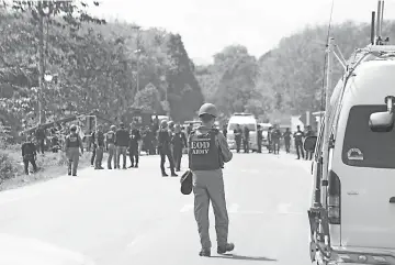  ?? — AFP photo ?? Thai police and military investigat­ors inspect the area following roadside bomb explosion by suspected militants in Thailand’s restive southern province of Narathiwat.