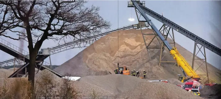  ??  ?? Mit einem schweren Kran versuchten die Einsatzkrä­fte an die Verschütte­ten heran zu kommen.