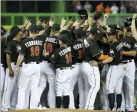  ?? LYNNE SLADKY — THE ASSOCIATED PRESS ?? Marlins players gather around the mound wearing the jersey of pitcher Jose Fernandez before Monday’s game against the New York Mets in Miami. Fernandez died in a boating accident Sunday.