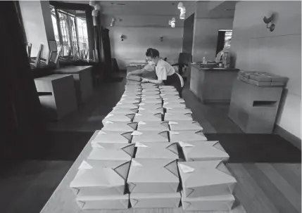  ?? Photos by Jeff Chiu, The Associated Press ?? Nightbird pastry chef Hope Waggoner prepares dinner boxes that were delivered to hospital workers in San Francisco through donations. Nightbird, an acclaimed restaurant, usually charges its diners $150 for a meal.