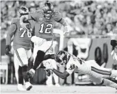  ?? JULIO AGUILAR GETTY IMAGES ?? Tampa Bay QB Tom Brady eludes the tackle of New York’s Tae Crowder in the second quarter.