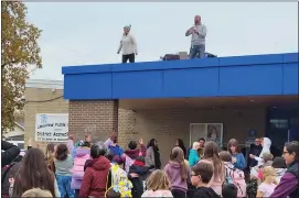  ?? SUSAN SMILEY — THE MACOMB DAILY ?? Princeton Elementary School principal Justin Cabe and Dean of Students Jen Donnelly toss candy to students on Nov. 3when they spent the day on the roof of the school.