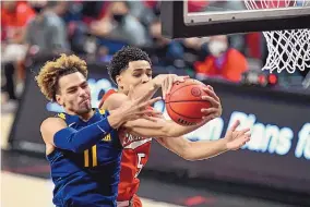  ?? JUSTIN REX/ASSOCIATED PRESS ?? West Virginia’s Emmitt Matthews (11) battles Texas Tech’s Micah Peavy for a rebound during Tuesday’s game in Lubbock, Texas. The Mountainee­rs beat Tech, 82-71.