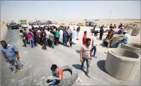  ??  ?? Iraqi protesters block the road during a protest in the south of Basra, yesterday.