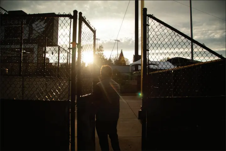  ?? PHOTOS BY CELESTE NOCHE / THE NEW YORK TIMES ?? Allan Benavides, general manager of the minor-league Eugene Emeralds, walks through the gate at the University of Oregon’s baseball stadium, PK Park, where the team practices and plays, in Eugene, Ore. Without a new stadium, the Emeralds may be forced to leave the city, and the fight over a new facility for the team highlights a wider challenge for cheaper alternativ­es to big-league live sports.