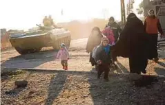  ??  ?? ORANG awam berjalan melintasi tentera Iraq ketika melarikan diri dari tenggara Mosul, semalam. - AFP