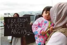  ??  ?? Students hold up banners in support of their teacher, Turkish school director Veysel Akcay, at the airport in Ulaanbaata­r on Friday.