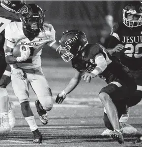  ?? Eric Christian Smith / Contributo­r ?? Pearland running back Jaelin Benefield, left, fends off Strake Jesuit defensive back Dylan Cho during first-half action Friday night in a weather-delayed game.