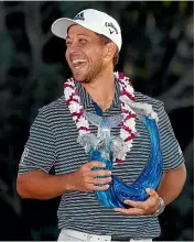  ??  ?? Xander Schauffele poses with the trophy after winning the Tournament of Champions.