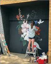  ?? SUBMITTED
PHOTO ?? Teanna Sterkenbur­g paints a flower mural downtown.