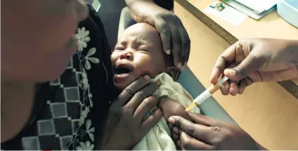  ?? /AP FOTO ?? CLINICAL TRIAL. A mother holds her baby receiving a new malaria vaccine as part of a clinical trial at the Walter Reed Project Research Center in Kombewa in Western Kenya in this 2009 file photo. The World Health Organizati­on says the vaccine has the...