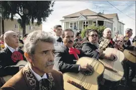  ?? Gabriella Angotti-Jones Los Angeles Times By Julia Barajas ?? MARIACHIS PARADE in Boyle Heights on Tuesday for the Festival of Santa Cecilia, patron saint of musicians, who has an altar near the subway entrance.