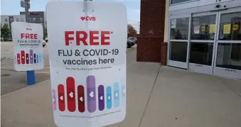  ?? NAncY lAnE / HErAlD STAff filE ?? NO IMMUNITY: Signs for flu and COVID vaccines outside a CVS in Foxboro on Thursday.