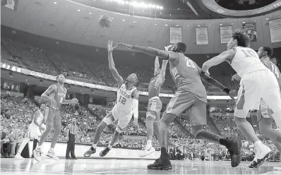  ?? AP Photo/Eric Gay ?? ■ Texas guard Kerwin Roach II (12) loses his balance while shooting after he was fouled by Radford guard Carlik Jones (1) during the second half of an NCAA college basketball game Friday in Austin. Radford won, 62-59.