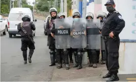  ?? Week. Photograph: Carlos Herrera/Reuters ?? Police officers keep watch outside the attorney general’s office where Félix Maradiaga, an aspiring opposition candidate, was summoned by authoritie­s, in Managua, Nicaragua, last