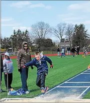  ?? PHOTO COURTESY OF SOMC ?? Cole Gemmill practices the long jump as his dad Dan Gemmill, left, tracks his progress.