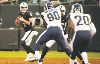  ?? Santiago Mejia / The Chronicle ?? Raiders quarterbac­k Derek Carr (4) threw two touchdown passes and finished 7-for-9 for 100 yards in Saturday night’s preseason game at the Oakland Coliseum.