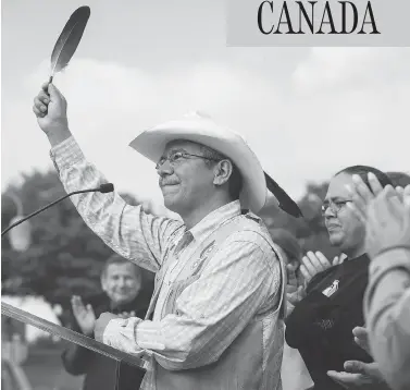  ?? DARRYL DYCK / THE CANADIAN PRESS ?? Coldwater Indian band Chief Lee Spahan raises an eagle feather in Vancouver after responding to a Federal Court of Appeal ruling Thursday that stalled the Trans Mountain Pipeline expansion.