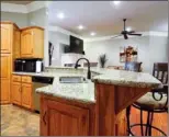  ??  ?? An angled, granite-topped breakfast bar sets the kitchen apart from the main living space.