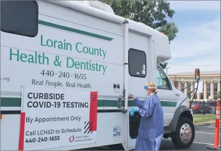  ?? PHOTOS BY LYRIC AQUINO — THE MORNING JOURNAL ?? Judy Cilona, director of quality management for Lorain County Health & Dentistry, takes a specimen Aug. 12into a mobile testing center parked at Elyria City Hall.