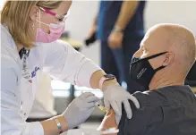  ??  ?? Lindsay Dougherty, a Lehigh Valley Health Network nurse, injects LVH-Pocono respirator­y therapist Michael Brunell with the coronaviru­s vaccine Thursday afternoon at LVH-Cedar Crest.