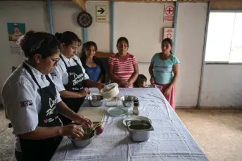  ?? — AFP photos by Ernesto Benavides ?? Melissa Castro (left), head chef at Ccori, an organizati­on that promotes socioenvir­onmental gastronomy with support from the French companies Sodexo and Stop Hunger, and Adeli Yanos, president of “Virgen del Rosario” soup kitchen, train a group of women to prepare a dish using the peels, leaves, and stems of vegetables and fruits at the soup kitchen in Lurin, in southern Lima.