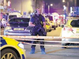  ?? YUI MOK/ASSOCIATED PRESS ?? An armed police officer mans a cordon on the Seven Sisters Road at Finsbury Park, where a vehicle struck pedestrian­s early today in London.