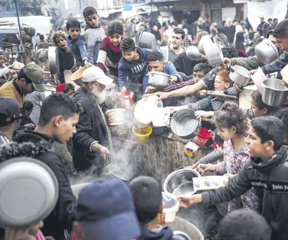  ?? ?? Palestinia­ns line up for a meal in Rafah, Gaza Strip, Palestine, Dec. 21, 2023.