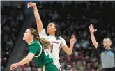  ?? SEAN RAYFORD/AP ?? South Carolina guard Zia Cooke, center, follows through on a 3-point basket against South Florida guard Aerial Wilson during the first half of a second-round game in the NCAA Tournament on Sunday in Columbia, S.C.