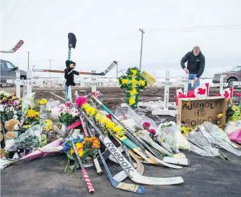  ?? BRANDON HARDER ?? Rocky Salisbury of Nipawin sets up crosses at the intersecti­on of Highway 35 and Highway 335, north of Tisdale, where a collision occurred involving the Humboldt Broncos hockey team bus that resulted in the deaths of 16 people. He said he didn’t know...