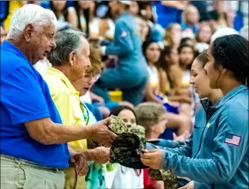  ?? PHOTO VINCENT OSUNA ?? Brawley union high school volleyball players honored former or active military members in attendance by giving them customized camouflage­d Buhs baseball cap during a special ceremony held Wednesday night at the Buhs gymnasium in Brawley.