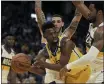  ?? BEN MARGOT — THE ASSOCIATED PRESS ?? Golden State Warriors’ Andrew Wiggins, left, looks to pass away from New Orleans Pelicans’ Derrick Favors, right, and Lonzo Ball in the second half on Sunday in San Francisco.