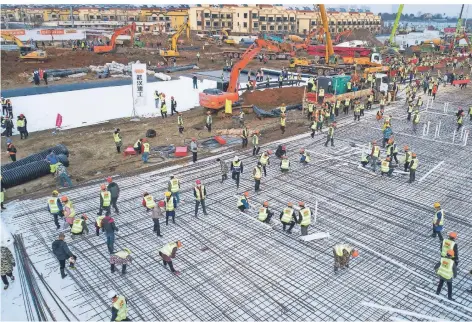  ?? FOTO: DPA ?? Bauarbeite­r arbeiten am provisoris­chen Feldkranke­nhaus Huoshensha­n, das in Wuhan gebaut wird. Es soll binnen anderthalb Wochen eröffnen.