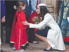  ?? Picture: AFP PHOTO ?? THANKS PETAL: Meghan Markle receives flowers from a young wellwisher outside Westminste­r Abbey yesterday.