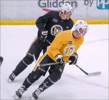  ?? Pittsburgh Penguins ?? Evgeni Malkin, rear, and Sam Lafferty eye the puck Wednesday on Day 3 of camp at the UPMC Lemieux Sports Complex in Cranberry.