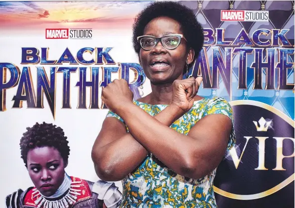  ?? — GETTY IMAGES ?? Dorothy Nyong’o, mother of Oscar-winning Mexico-born Kenyan actress Lupita Nyong’o, poses with banners before watching Black Panther in Kisumu, Kenya. Nyong’o is among the diverse cast in the widely hailed box-office hit.